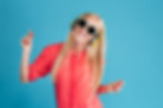 portrait-of-a-smiling-cheerful-blonde-woman-in-sunglasses-listening-music-with-headpho-SBI